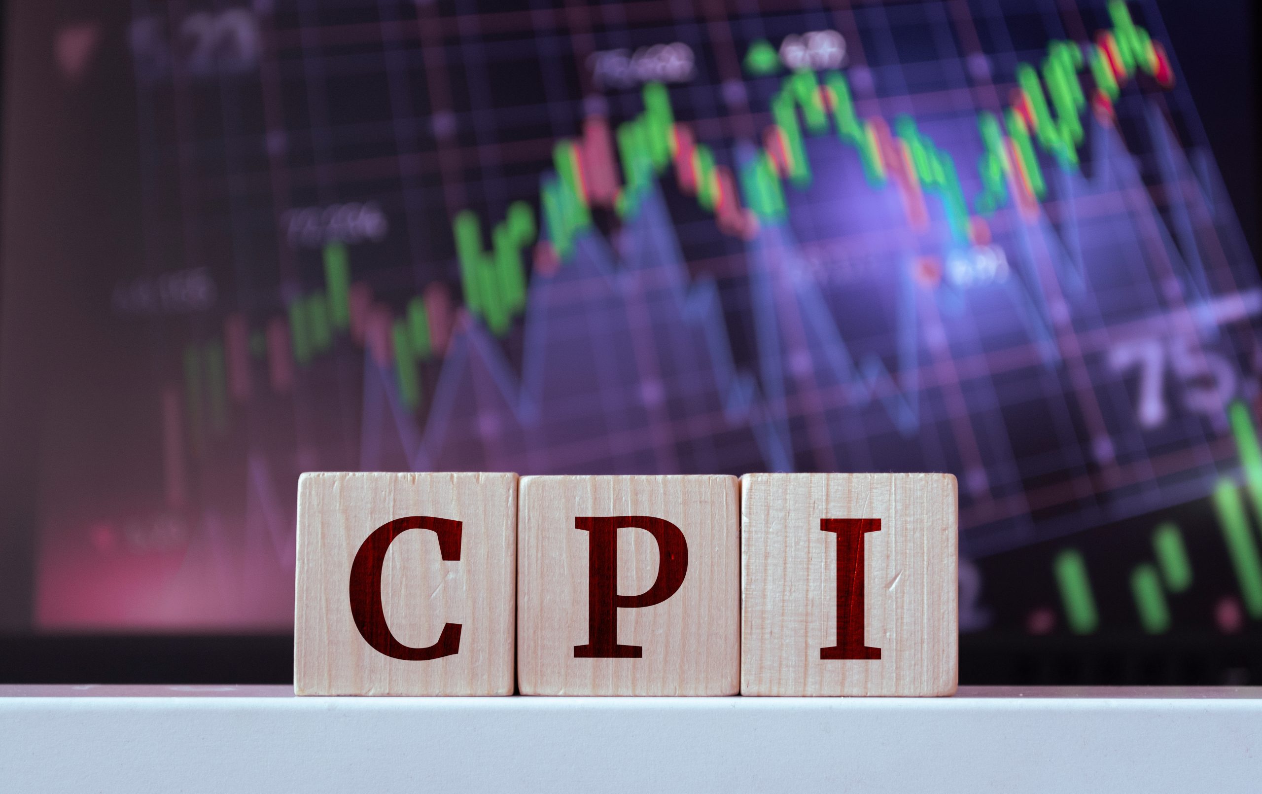 Wooden blocks in the foreground spell 'CRIT' with a blurred financial chart in the background.